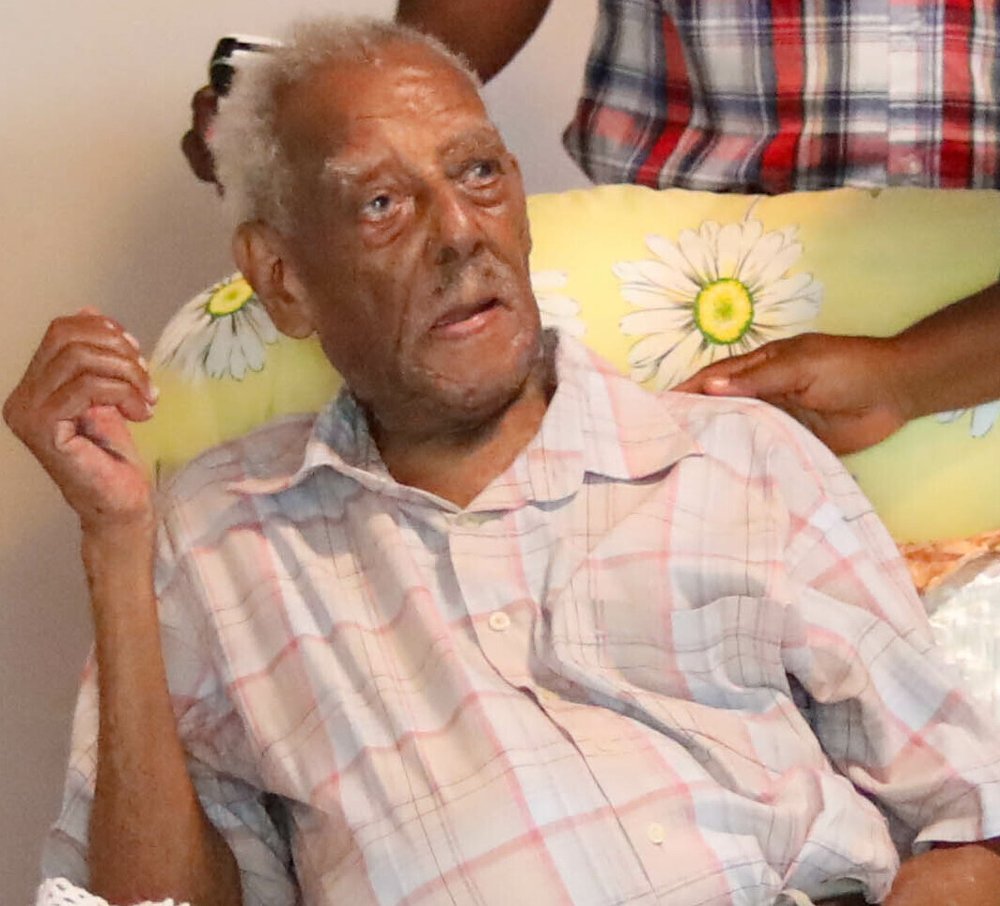 Walter Ferguson, anciano, sentado y conversando, con camisa a cuadros.